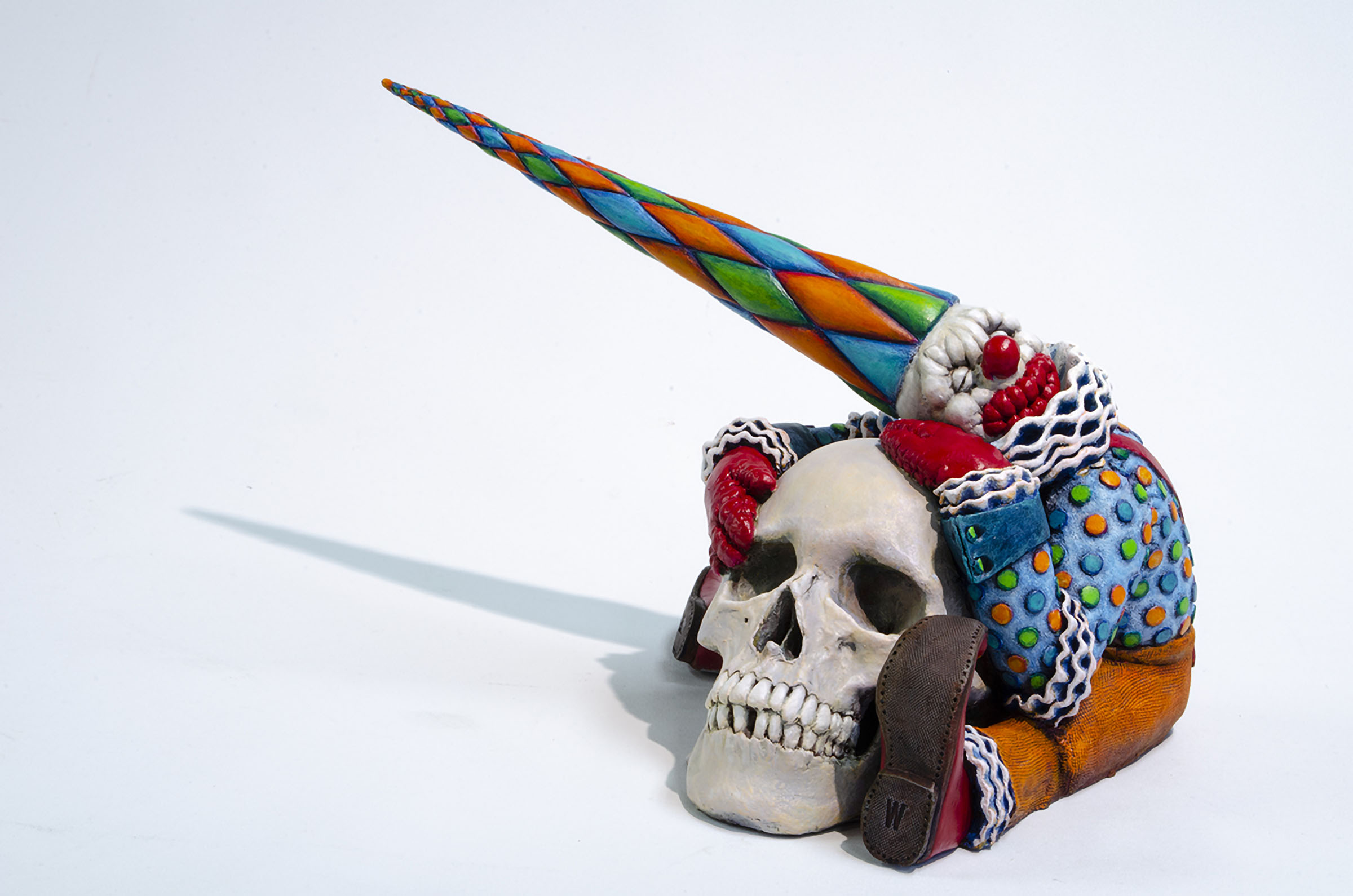 William Fillmore Painted Stonware Sculpture of Sitting Clown Figure Emracing a Human Skull